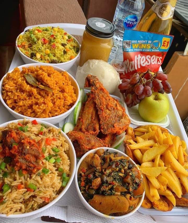 A takeaway tray of jollof rice, fried fish and plantain