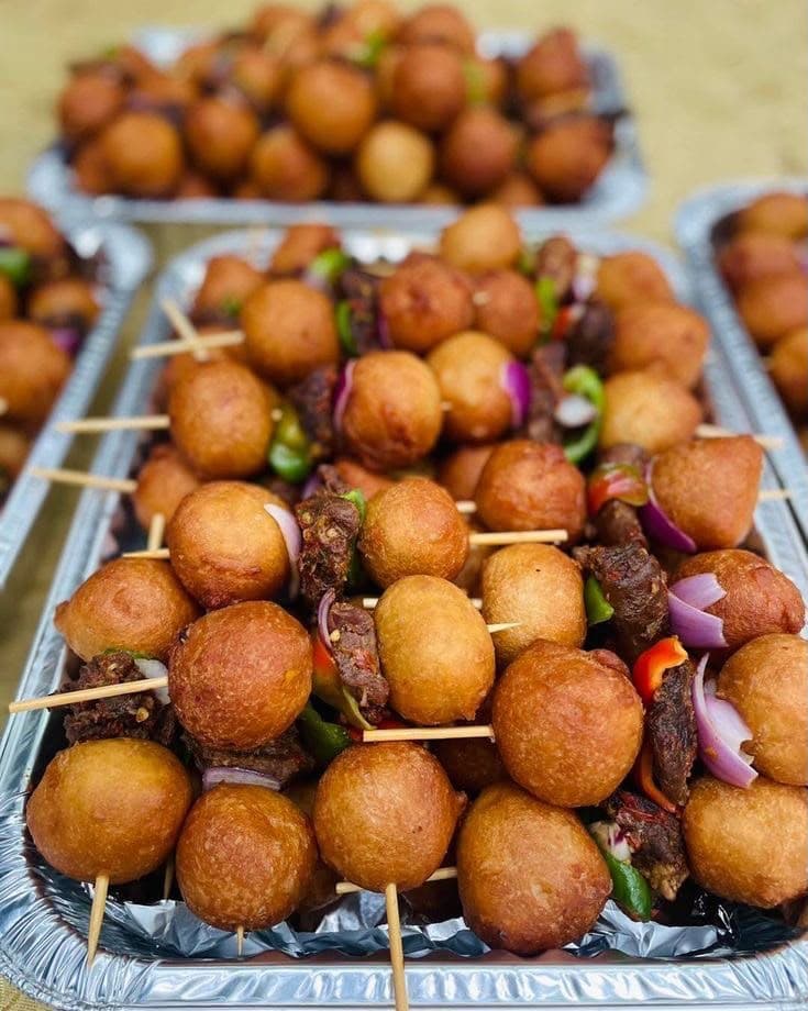 Trays of puff puff and suya skewers