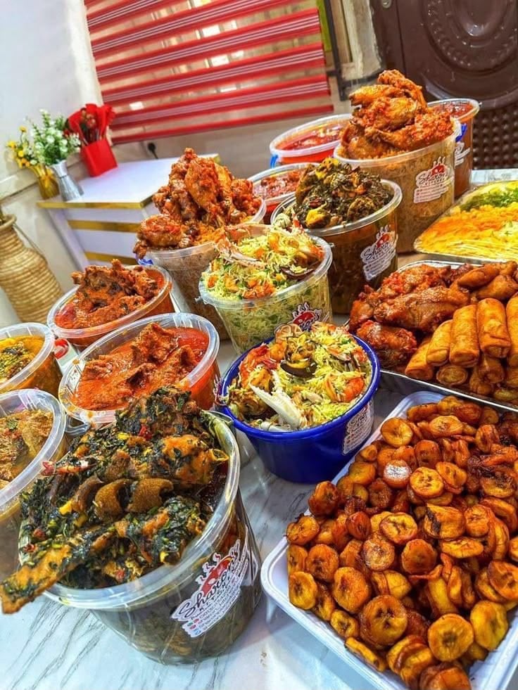 A wide spread of jollof rice, soups, coconut rice and fried plantain prepared for an event